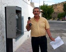 Un veciño usando o teléfono público de Los Villares