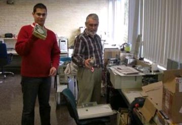 Voluntarios amosando a A Nosa Terra as pezas coas que montan os equipos reciclados